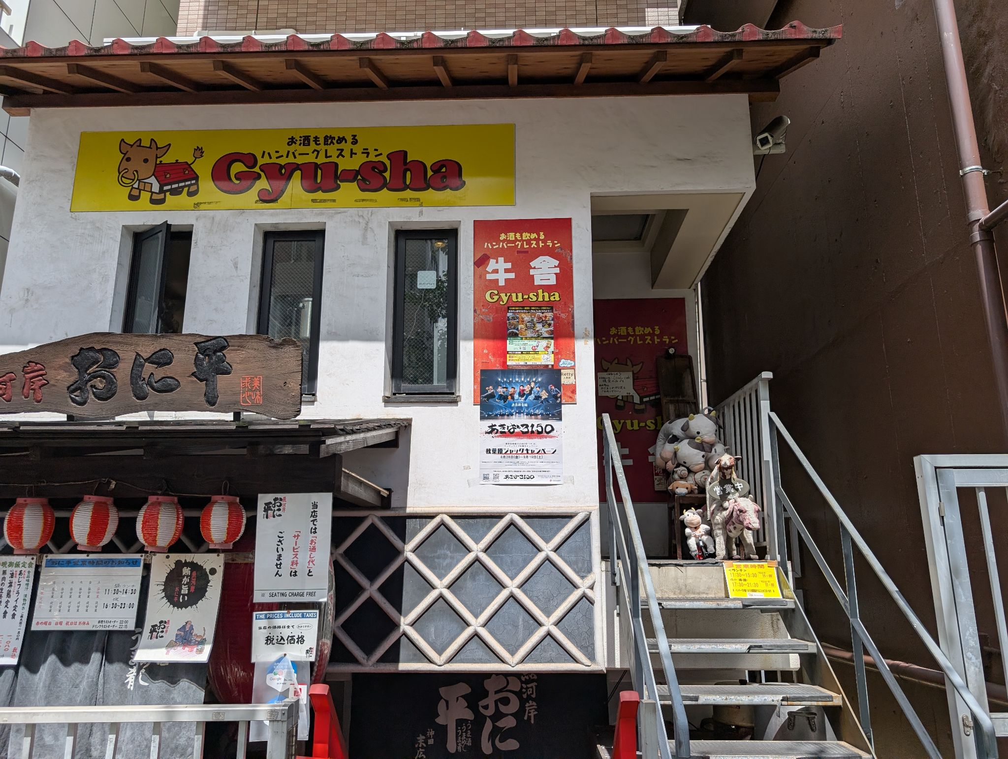 黄色い牛舎の看板と店へ上がる階段